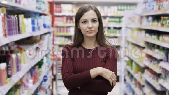 考虑周到的年轻漂亮女人在考虑超市的决定时摸了摸她的脸视频的预览图