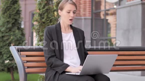 背疼的年轻女商人在户外笔记本电脑工作视频的预览图