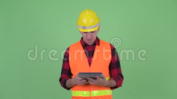 幸福青年多民族建筑工人用数字平板电脑思考视频的预览图