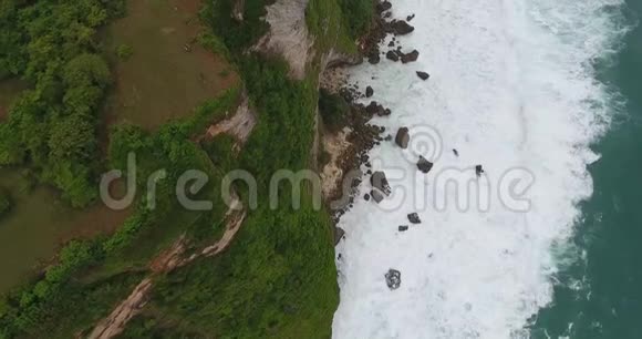 海岸线上美丽的景色有巨大的悬崖和泡沫般的波浪阴天4k视频的预览图