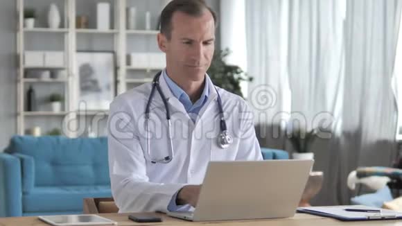 高级医生在诊所电脑打字发送电子邮件视频的预览图