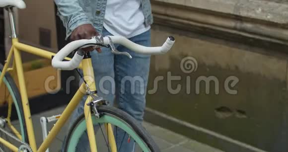 一个面目全非的美国黑人男人的手举着一个现代时尚自行车手视频的预览图