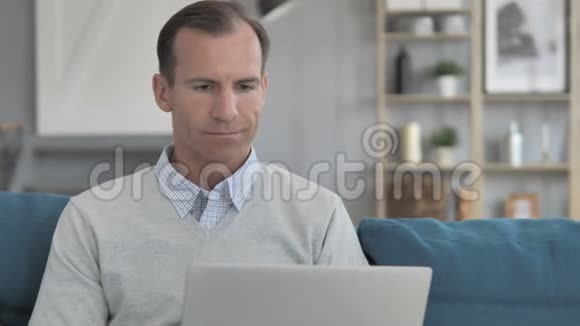 中年男子在创意工作场所进行笔记本电脑在线视频聊天视频的预览图