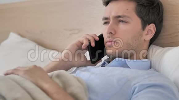 放松的年轻人在床上打电话视频的预览图