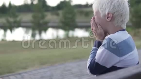一个白化病男孩坐着开心地笑视频的预览图