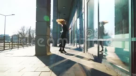 在阳光明媚的城市街道上一位金发女郎一位当代舞者在表演她的舞蹈视频的预览图