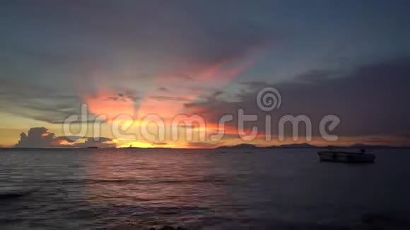 美丽的日落和云彩在海滩上随着岩石和船就像天堂和天堂视频的预览图