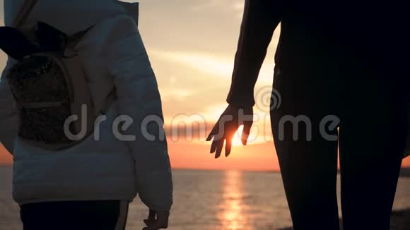 日落时分小女儿在沙滩上向母亲伸出手来视频的预览图