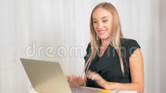 女孩正在一台金色的笔记本电脑后面工作视频的预览图