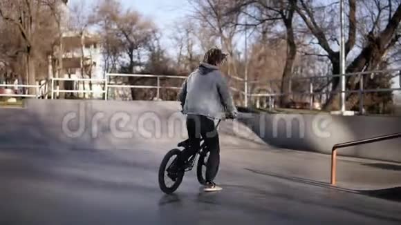 一个男孩正在阳光明媚的日子里在滑板公园骑自行车爱好娱乐体育生活视频的预览图