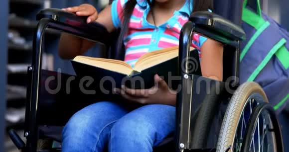 残疾非裔美国女学生在4k学校图书馆看书的正面观察视频的预览图