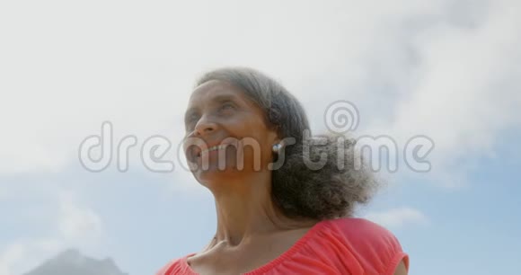 活跃的非裔美国老年妇女在海滩阳光下伸展手臂的低角度视角视频的预览图