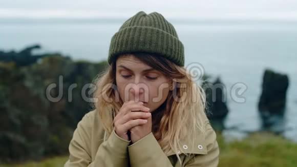 年轻女子在挪威用呼吸温暖双手视频的预览图