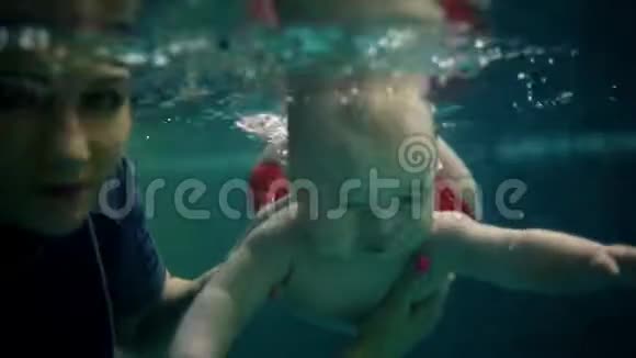 幸福的家庭母亲带着小儿子潜入水下在游泳池里玩得很开心健康的生活方式积极的父母视频的预览图