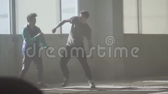 两个熟练的舞者在废弃建筑的大窗户前跳舞青少年在跳舞视频的预览图
