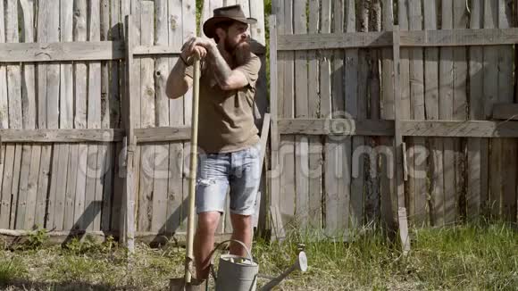 希普斯特农民在自然背景下放松一个长胡子的农夫拿着铲子在农场里玩视频的预览图