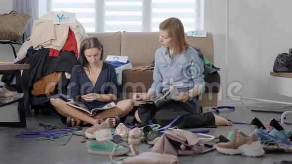 两个朋友决定安排一个衣柜女人很累坐在地板上放松看杂志视频的预览图