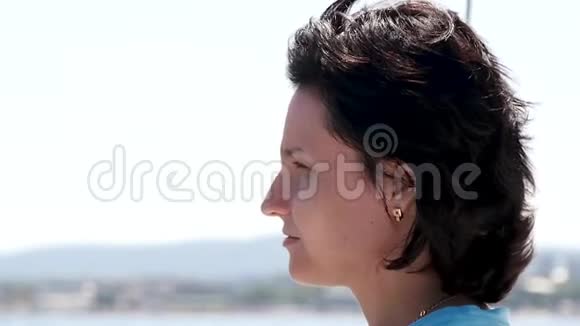 夏季海上航行中一个女孩在游艇上的肖像一个年轻女人的脸头发随风飘扬视频的预览图