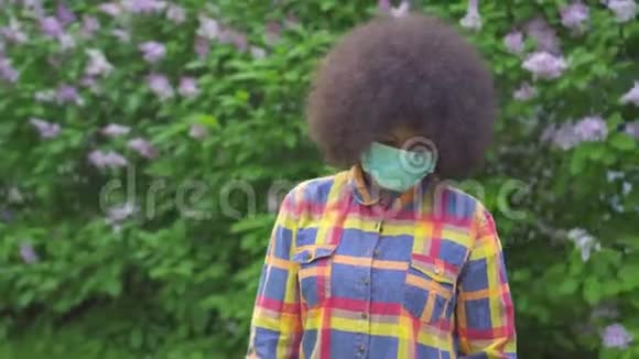 美国黑人妇女肖像留着非洲发型戴着医用防护面具视频的预览图