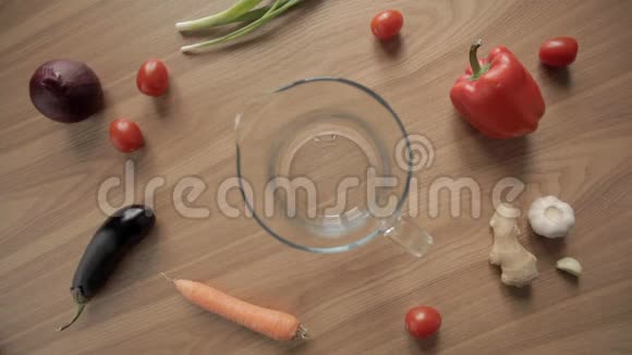 在木桌上将新鲜水倒入装有新鲜蔬菜的玻璃壶中视频的预览图
