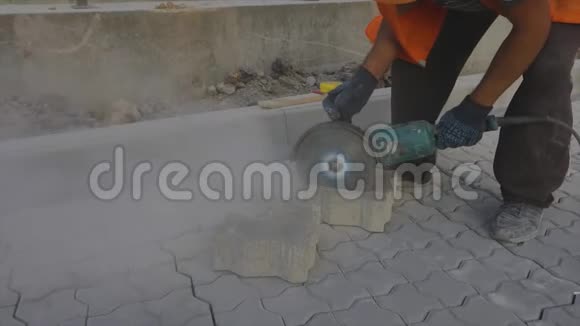一名工人正在用磨床切割一块石瓦一名工人正在用磨床切割一块砖视频的预览图