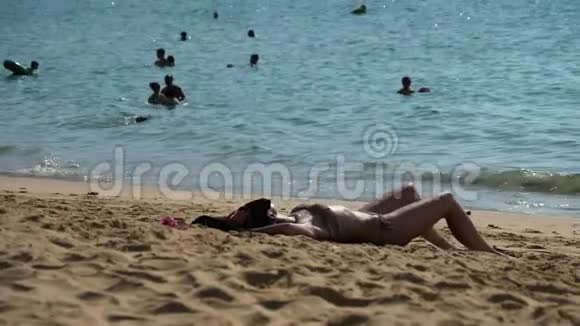 在海滩上晒日光浴的女孩视频的预览图