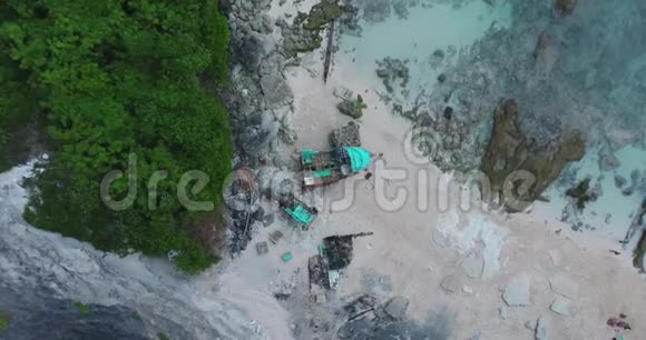 在热带岛屿海滩上的一艘船的残骸上旋转俯视图视频的预览图