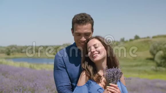 可爱的情侣在盛开的薰衣草花田里结缘视频的预览图