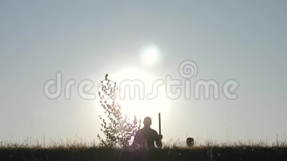 农民的幸福家庭一位父亲和两个孩子在日落时在公园里种树和浇水的剪影视频的预览图