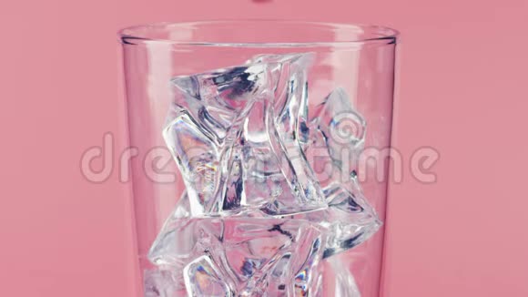 将粉红色的饮料倒入带有粉红色背景的冰块的玻璃杯中用红色拍摄特写慢镜头视频的预览图