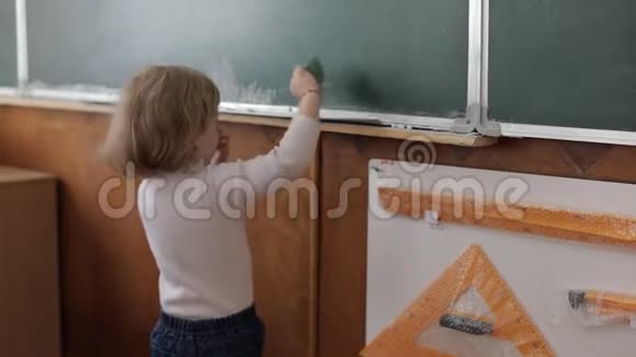 女孩在教室里用毛巾擦黑板教育进程视频的预览图