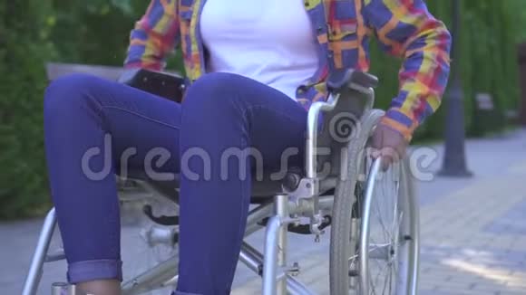 阳光公园轮椅残疾的年轻非洲裔美国妇女积极微笑的肖像视频的预览图