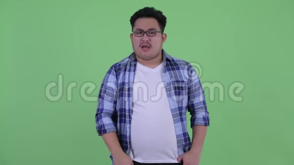 悲伤的年轻超重的亚洲时髦男人竖起大拇指视频的预览图