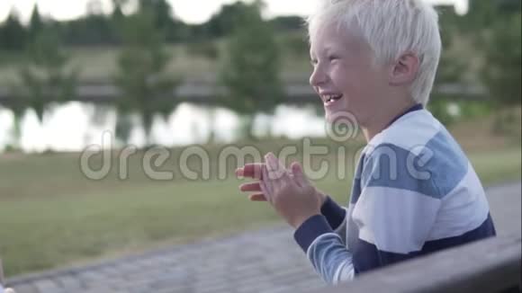 一个金发男孩在散步时愉快地笑着视频的预览图