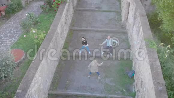 无人机拍摄的三个朋友在意大利老城做有趣的舞蹈视频的预览图