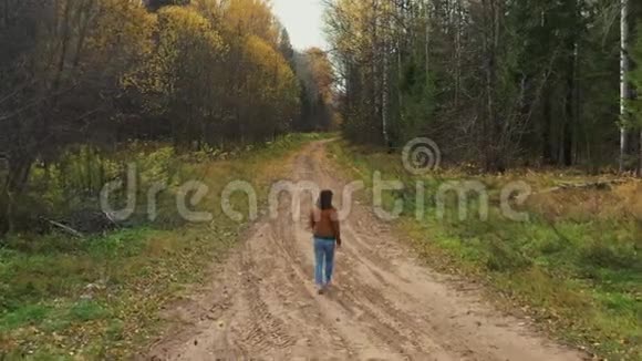 美丽微笑的白种人女人走在秋天的树林里环顾四周享受大自然的美丽徒步旅行爱好视频的预览图
