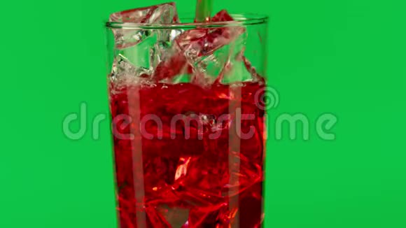 将红色饮料倒入杯中在绿色背景下加入冰块特写慢动作拍摄红色视频的预览图