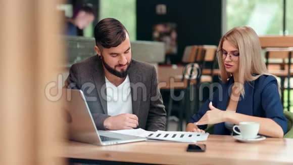 商人和女商人在咖啡馆举行非正式商务会议讨论项目视频的预览图