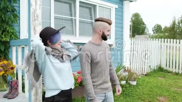 年轻的家庭男人和女人在一个蓝色的木屋背景上视频的预览图