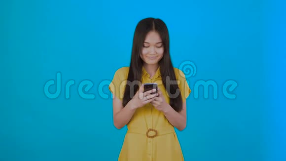 韩国亚洲女性在深蓝色背景下仔细阅读新闻女孩手机拷贝空间4K视频的预览图