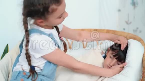小可爱的女孩在椅子上睡着了姐姐抚摸她动作很慢视频的预览图