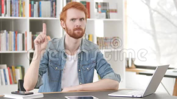 红发男子在工作中挥舞手指拒绝视频的预览图