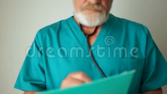 成熟的男医生留着灰色的胡须和眼镜微笑着看着相机医药和保健概念视频的预览图