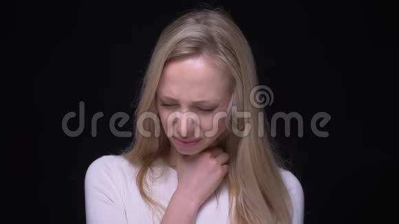 一位年轻漂亮的金发女性的特写镜头她喉咙不适在镜头前咳嗽背景是视频的预览图