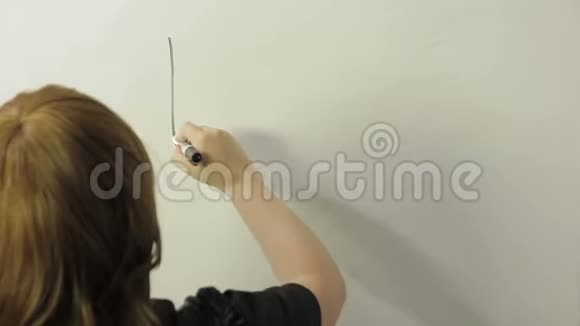 一个女人背着她站着在白板上画一个货币和图形的符号时间跨度视频的预览图