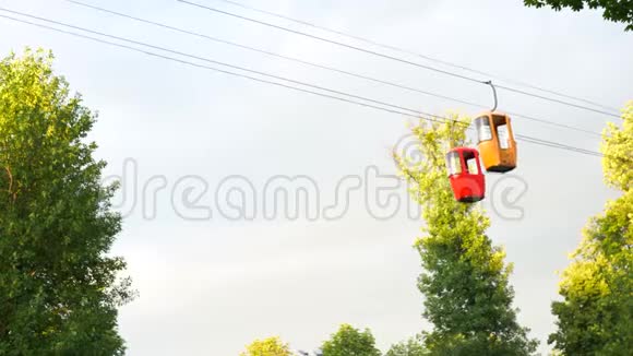 在缆车上观看乘坐小货车骑在树冠上夏天阳光明媚视频的预览图