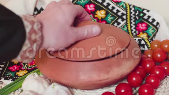 烹饪桌热罗宋汤穿乌克兰衣服的人的手打开盖子慢动作视频的预览图