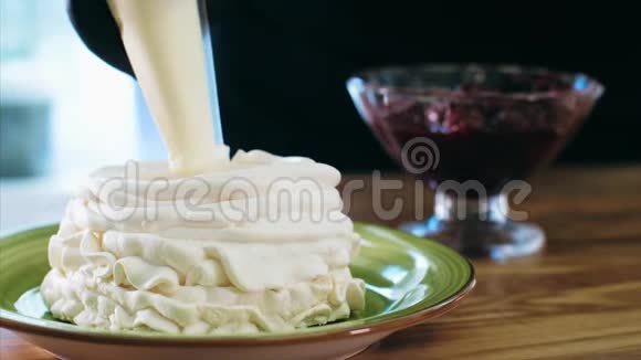 厨师用奶油和樱桃果酱烹饪奶油蛋糕视频的预览图