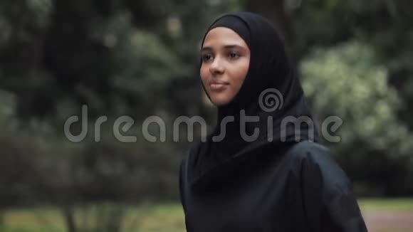 年轻的PreetyMuslin女孩穿着Hijab跑步在公园的右侧观概念健康生活方式视频的预览图