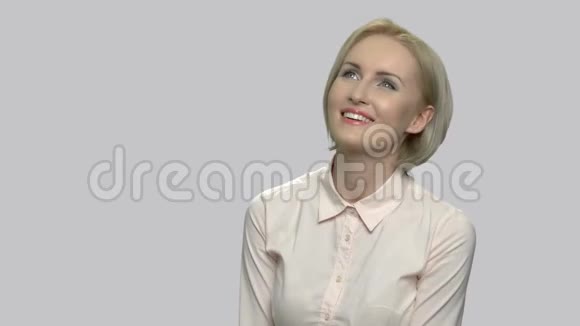 灰色背景下快乐的白日梦女人视频的预览图